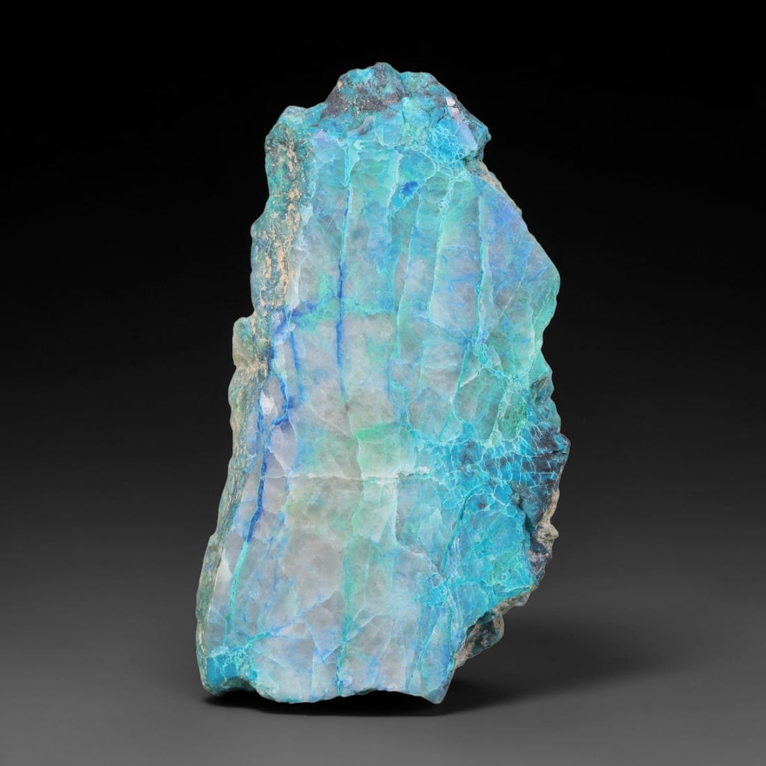 154.35ct Natural Peruvian Chrysocolla Polished Slab Rough, 65EK: This partial-polished chrysocolla slab features blended mineral matrix with smooth refined face and unaltered natural rugged edge across its 60x34x8mm elongated form, translucent mineral layers hold s