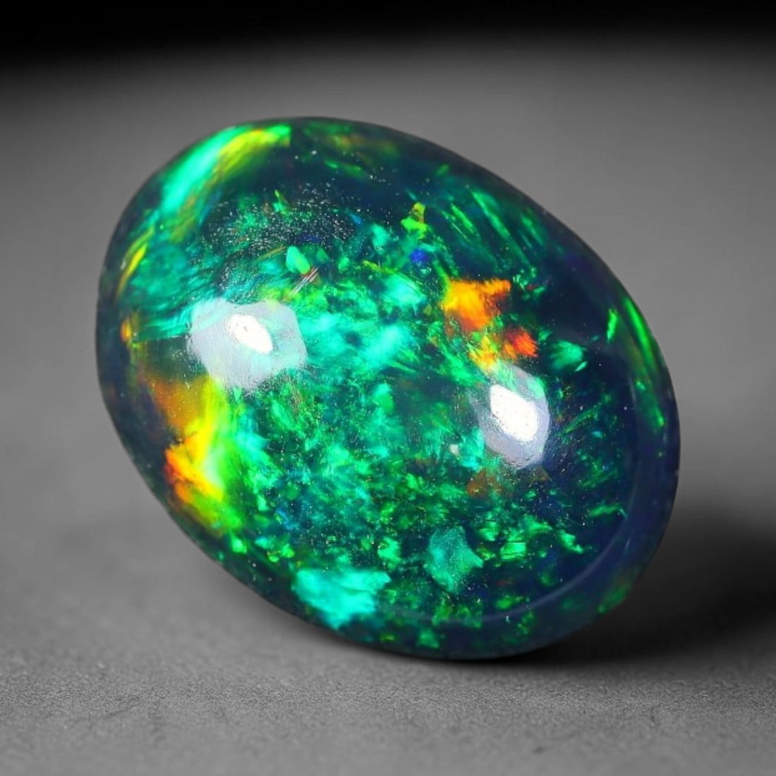 1.64ct Natural Ethiopian Welo Black Smoked Opal Cabochon Loose Gemstone, 2FX: This fully polished Ethiopian Welo opal features a dark smoked base with vivid, sweeping play-of-color shifting across its glossy dome surface, measured at 10x8x4mm. The black smoke treatment deepens 