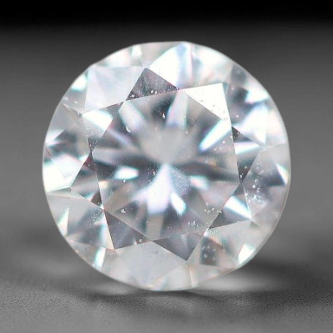 0.11ct Lab-Grown White Round Brilliant HPHT Diamond Loose Gemstone, 82BE: This precision-cut HPHT lab-grown diamond exhibits brilliant colourless transparency, dotted with subtle microscopic growth features within its crystal structure, measured at calibrated dimensions of 