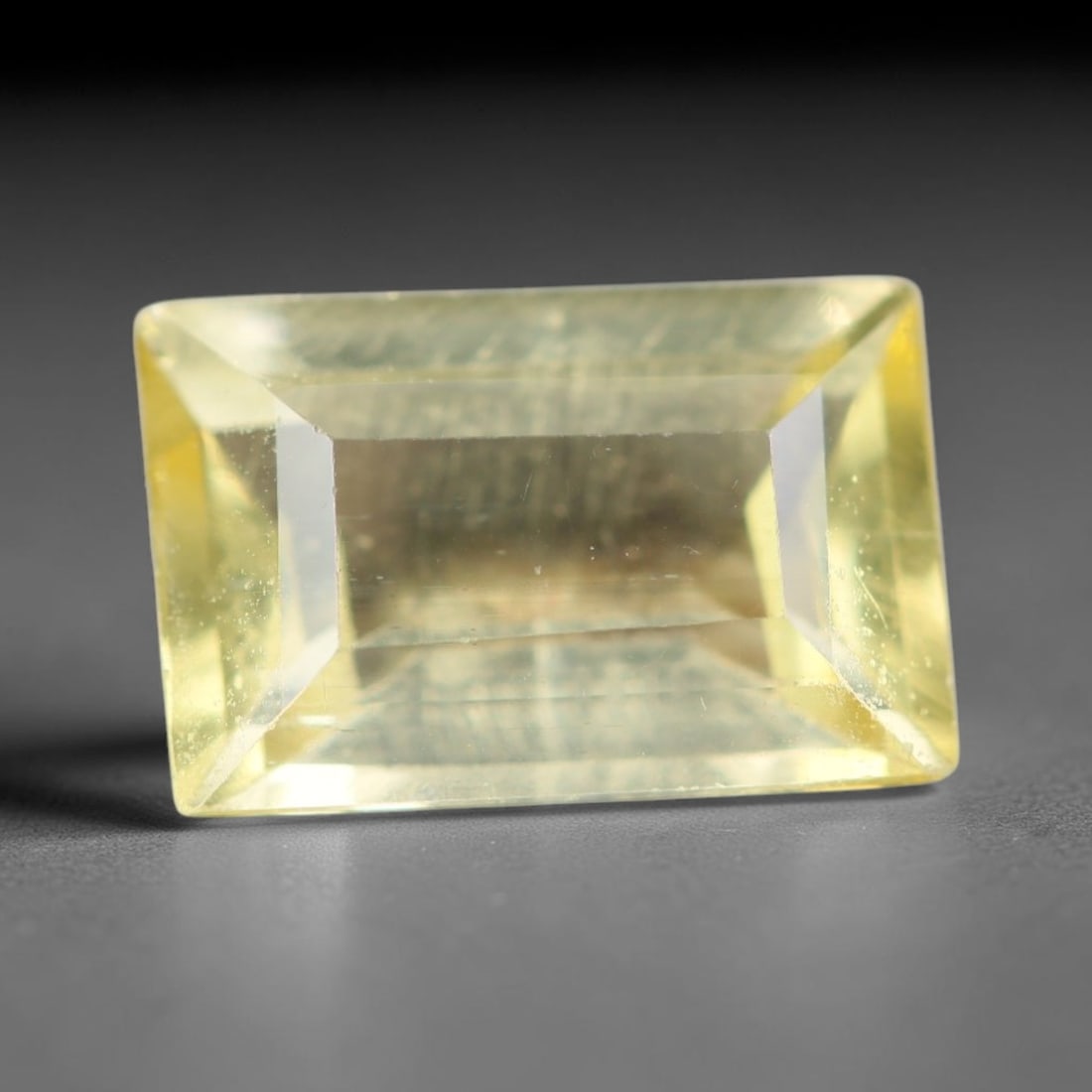 1.75ct Natural Mexican Lemon Yellow Faceted Apatite Loose Gemstone, 87AR: This expertly faceted yellow apatite holds translucent pale lemon yellow crystal structure with faint tiny internal mineral specks and subtle fine linear markings visible beneath its precisely polishe