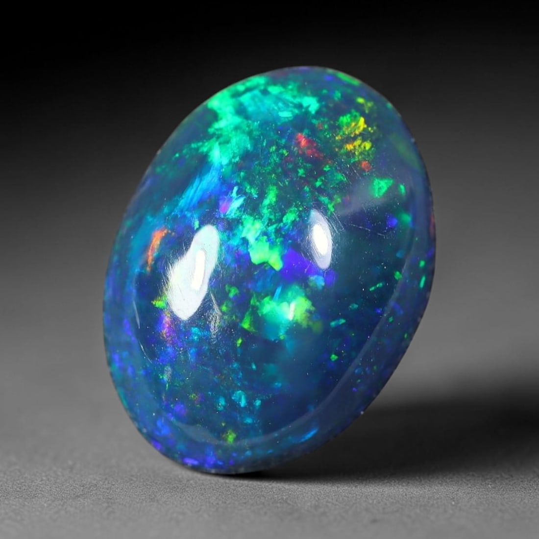 2.10ct Natural Ethiopian Welo Black Smoked Opal Cabochon Loose Gemstone, 63FX: This fully polished Ethiopian Welo opal features a dark smoked base with vivid, sweeping play-of-color shifting across its glossy dome surface, measured at 11x8x4mm. The black smoke treatment deepens 