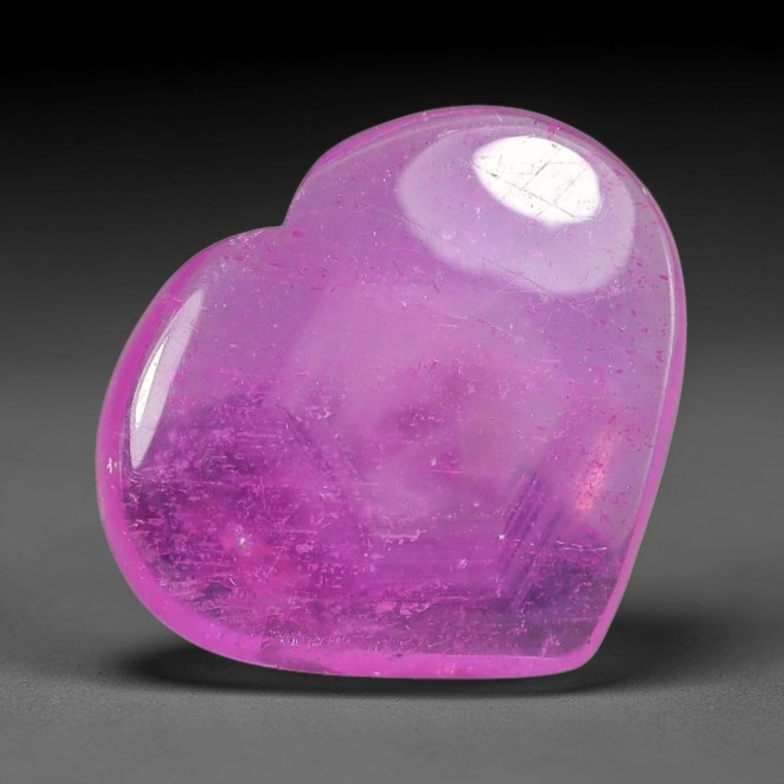 3.53 Carats Natural Mozambique Hot Pink Ruby Loose Gemstone, 68FE: This heart shaped Mozambique ruby cabochon measures 12.5x10.8x2.4mm, showcasing a vivid saturated hot pink body paired with stunning natural hexagonal crystal growth banding that forms a distinct geom
