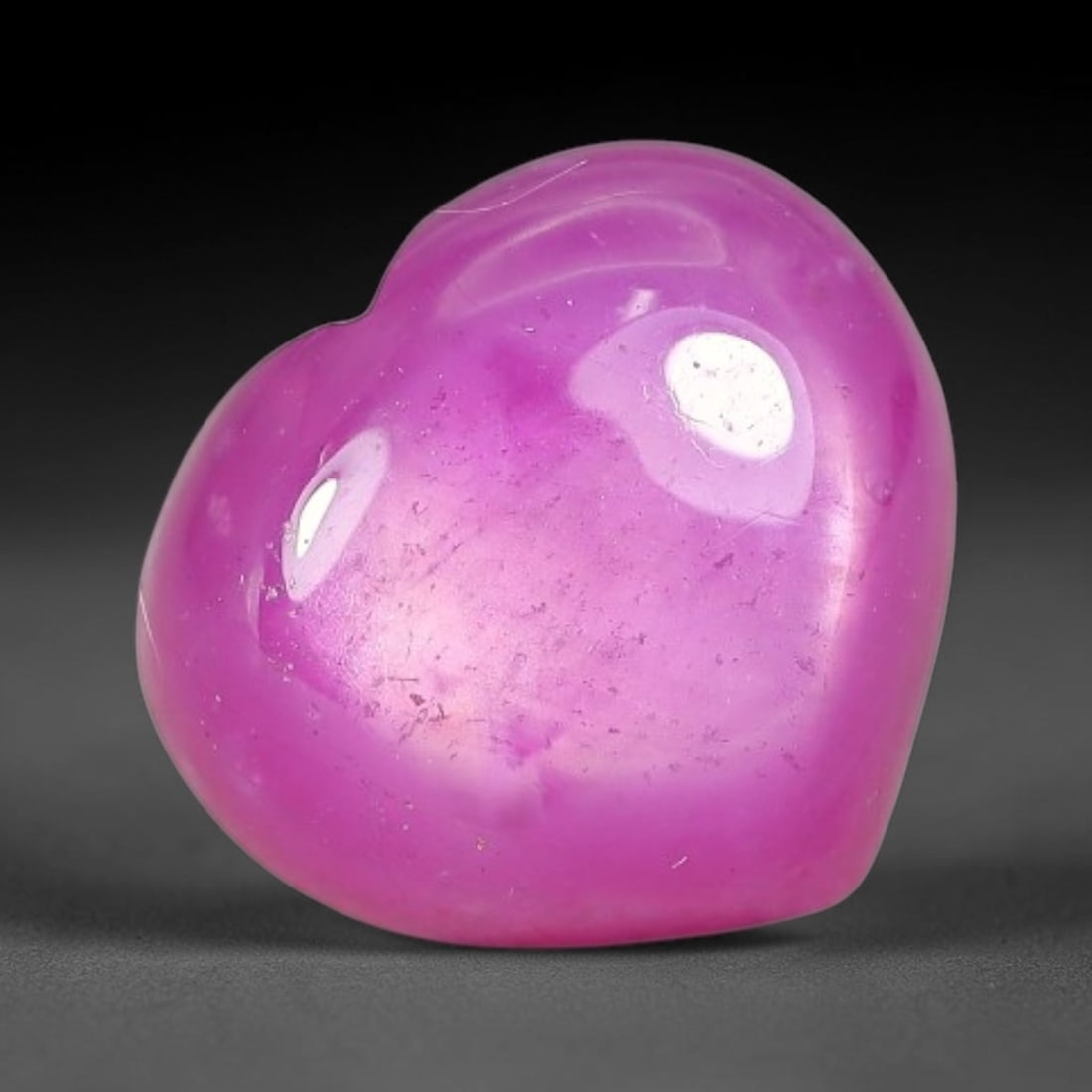 6.09 Carats Natural Mozambique Hot Pink Ruby Loose Gemstone, 56FE: This heart shaped Mozambique ruby cabochon measures 10.4x9.4x5.3mm, showcasing a vivid saturated hot pink body paired with stunning natural hexagonal crystal growth banding that forms a distinct geome