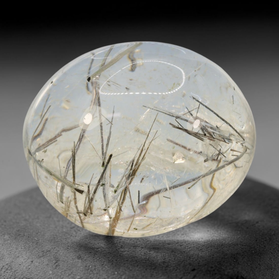 26ct Natural Brazilian Black Rutile Quartz Cabochon Loose Gemstone, 60BM: This polished cabochon of natural rutile quartz features countless distinct slender black rutile needle inclusions suspended within the clear quartz host crystal. The smooth domed surface enables full