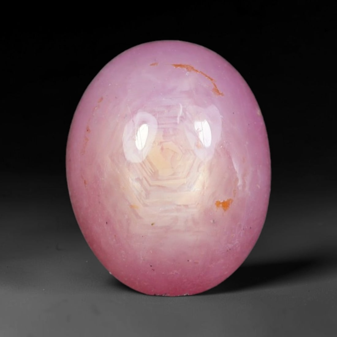 5.68ct Natural Mozambican Soft Bubblegum Pink Ruby Cabochon Loose Gemstone, 94AR: This smoothly polished domed ruby cabochon displays a gentle soft bubblegum pink body tone with faint natural linear mineral veining and tiny scattered rust-hued mineral flecks embedded within its tra