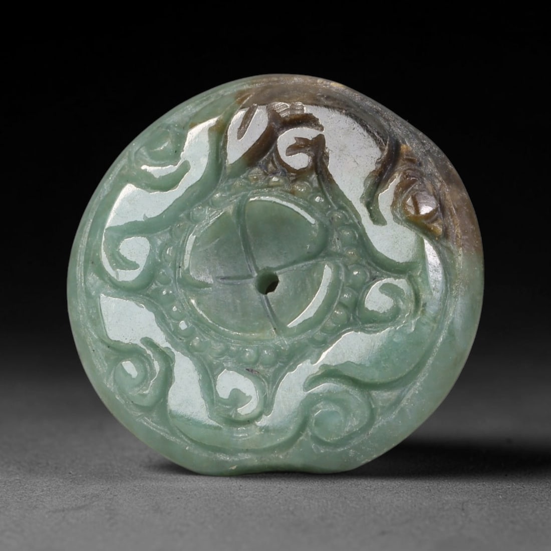 Natural Burmese Type A Jadeite Jade Carved Disc Pendant, 38BP: Artisan hand-carved untreated Burmese Type A jadeite jade circular disc pendant with a 26 mm diameter. The surface is adorned with detailed traditional relief carving finished with a smooth polished s