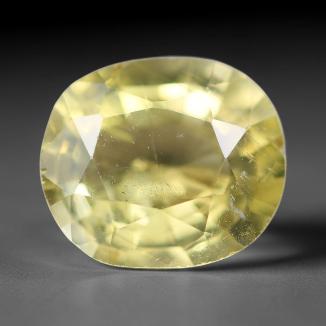 3.22ct Natural Mexican Lemon Yellow Faceted Apatite Loose Gemstone, 26BC: This expertly faceted yellow apatite holds translucent pale lemon yellow crystal structure with faint tiny internal mineral specks and subtle fine linear markings visible beneath its precisely polishe