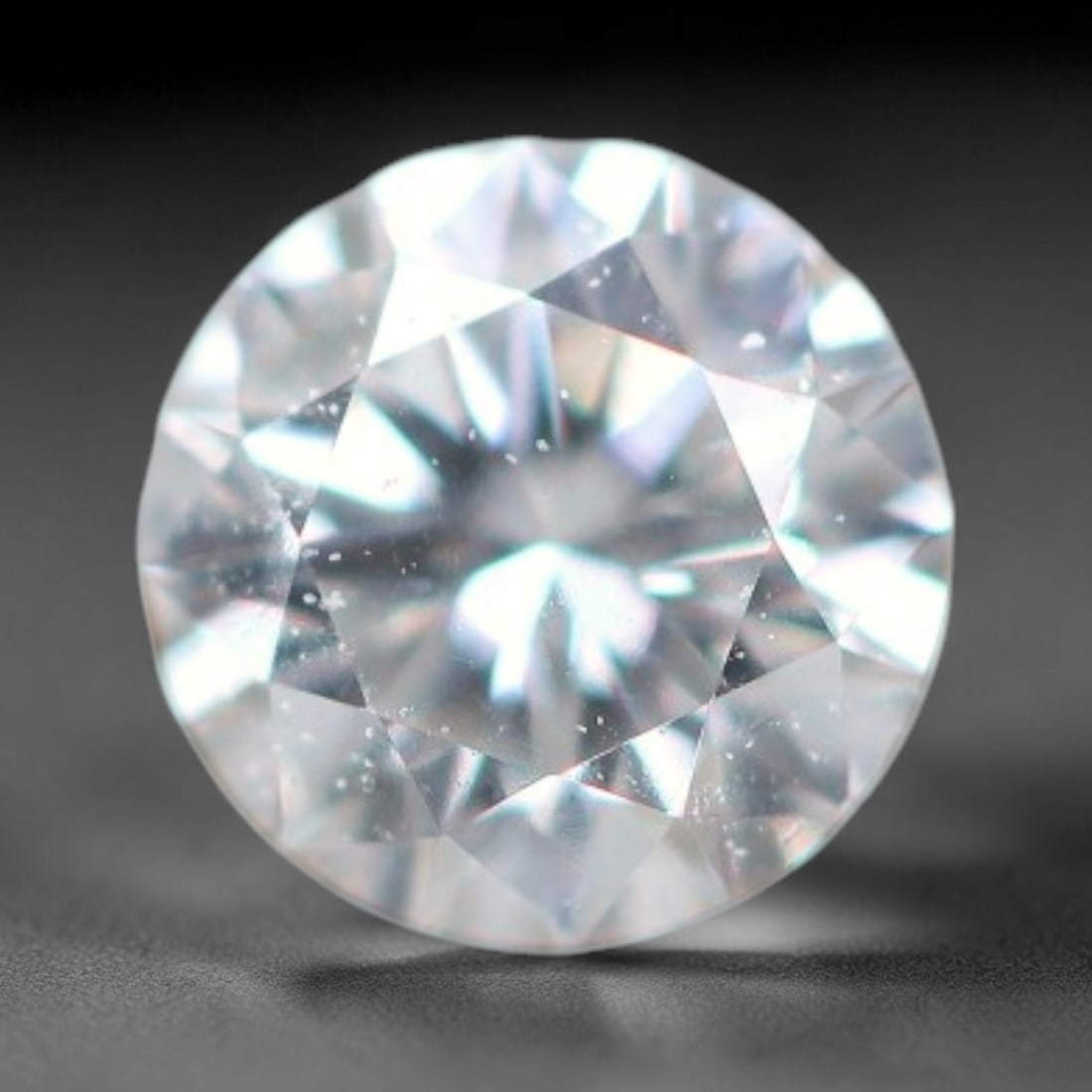 0.13ct Lab-Grown White Round Brilliant HPHT Diamond Loose Gemstone, 83BE: This precision-cut HPHT lab-grown diamond exhibits brilliant colourless transparency, dotted with subtle microscopic growth features within its crystal structure, measured at calibrated dimensions of 