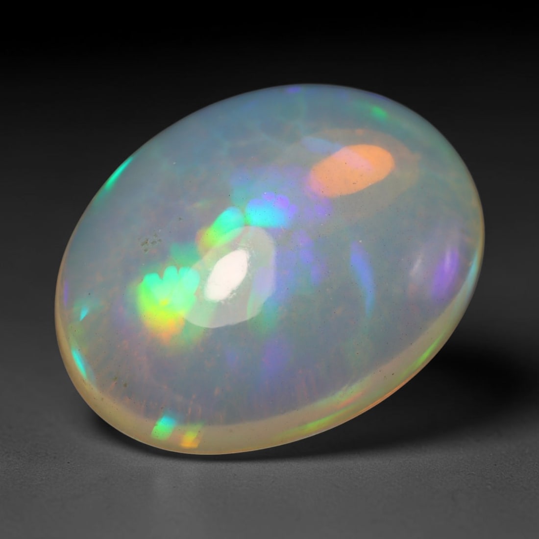 4.71ct Natural Ethiopian Welo Opal Cabochon Loose Gemstone, 21BY: This smoothly polished cabochon is genuine natural Ethiopian Welo opal. The translucent base hosts vivid multi-coloured play-of-colour, displaying dynamic flashes of multi color that shift as the view