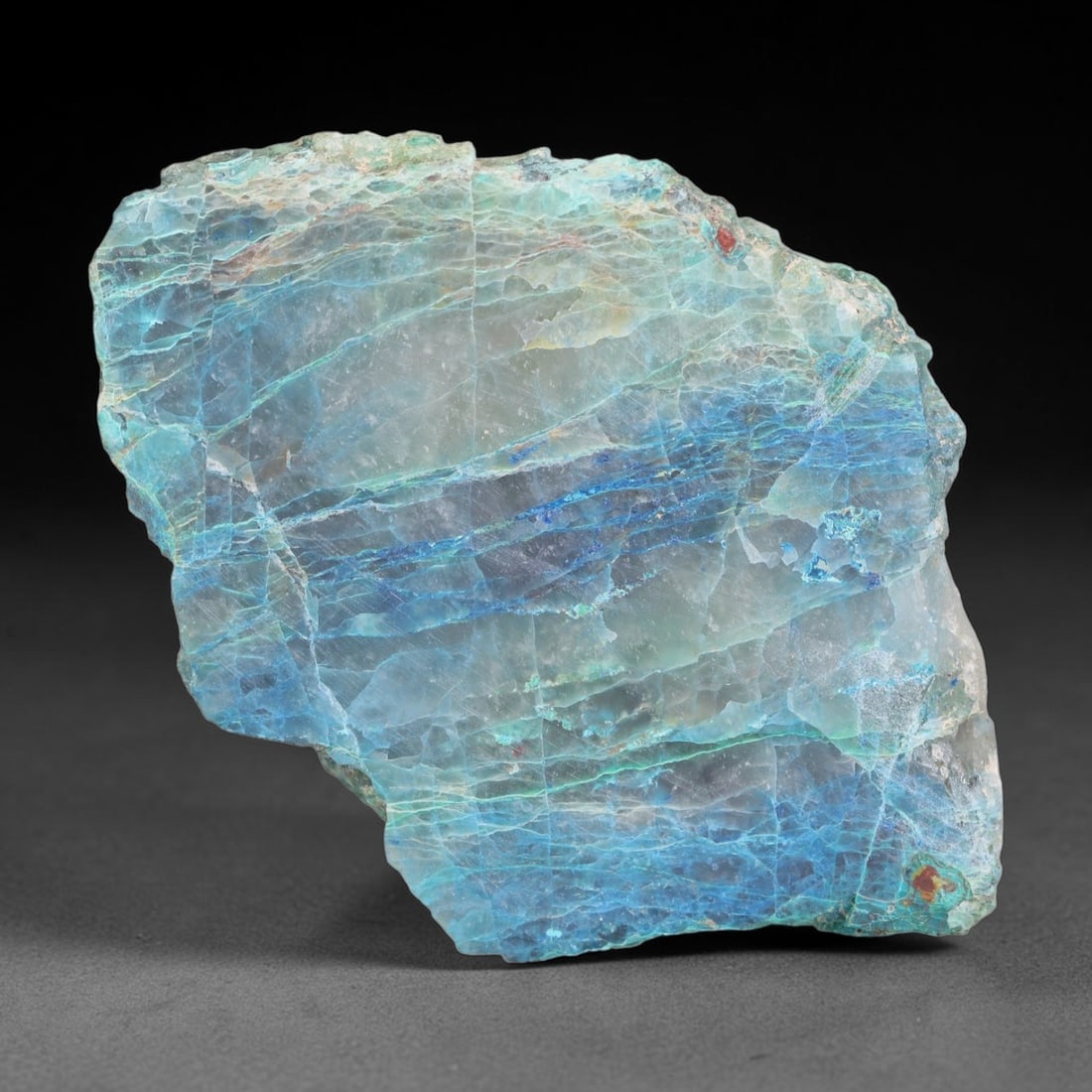 104.57ct Natural Peruvian Chrysocolla Polished Slab Rough, 62EK: This partial-polished chrysocolla slab features blended mineral matrix with smooth refined face and unaltered natural rugged edge across its 55x38x6mm elongated form, translucent mineral layers hold s