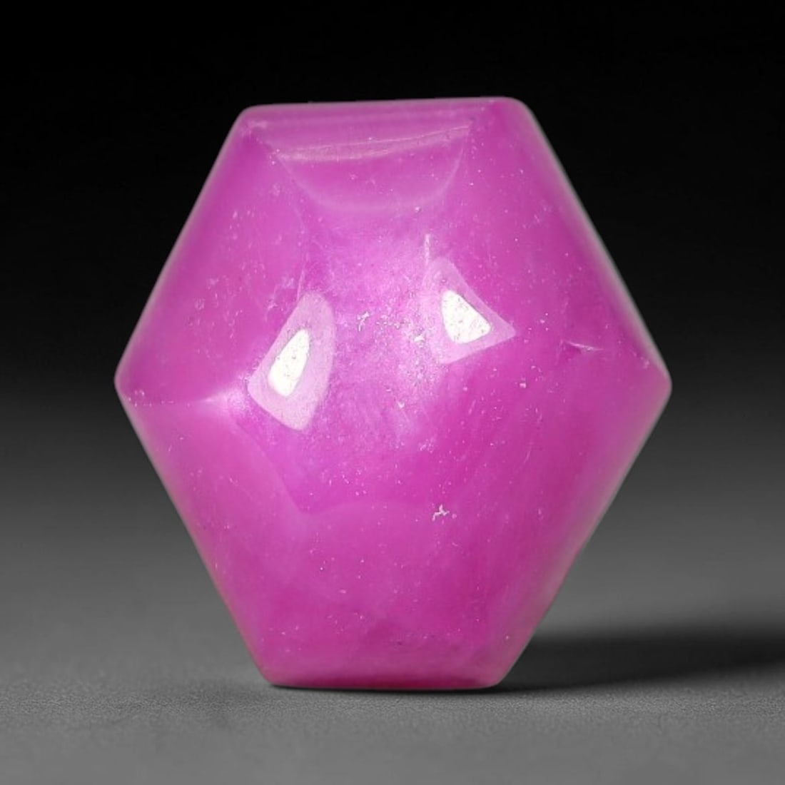 7.65 Carats Natural Mozambique Hot Pink Ruby Loose Gemstone, 67FE: This heart shaped Mozambique ruby cabochon measures 10.6x9.1x6.4mm, showcasing a vivid saturated hot pink body paired with stunning natural hexagonal crystal growth banding that forms a distinct geome