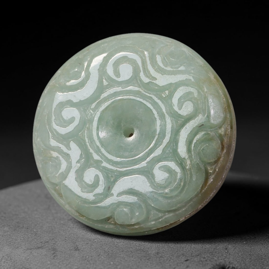 Natural Burmese Type A Jadeite Jade Carved Disc Pendant, 50BP: Artisan hand-carved untreated Burmese Type A jadeite jade circular disc pendant with a 27 mm diameter. The surface is adorned with detailed traditional relief carving finished with a smooth polished s