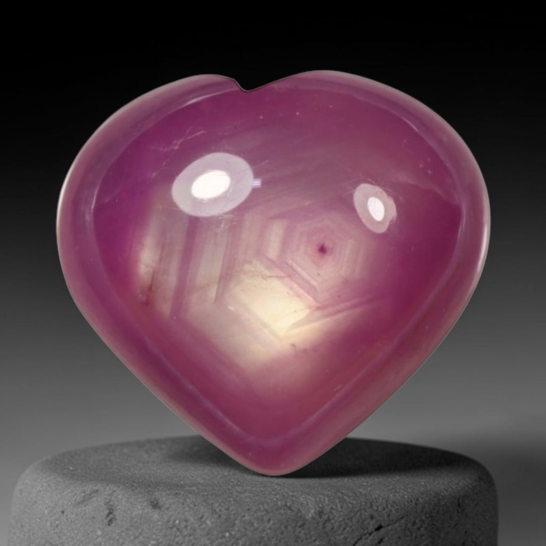 4.89ct Natural Mozambique Hot Pink Ruby Loose Gemstone, 62BP: This heart shaped Mozambique ruby cabochon measures 10.3x9.5x4.7mm, showcasing a vivid saturated hot pink body paired with stunning natural hexagonal crystal growth banding that forms a distinct geome
