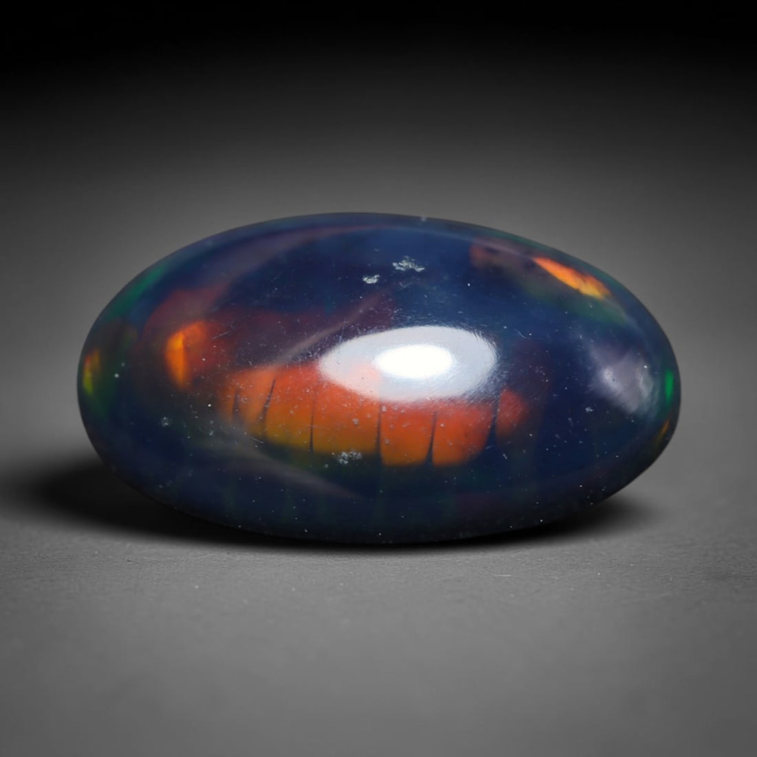 2.54ct Natural Ethiopian Welo Black Smoked Opal Cabochon Loose Gemstone, 54BY: This fully polished Ethiopian Welo opal features a dark smoked base with vivid, sweeping play-of-color shifting across its glossy dome surface, measured at 14x9x4mm. The black smoke treatment deepens 