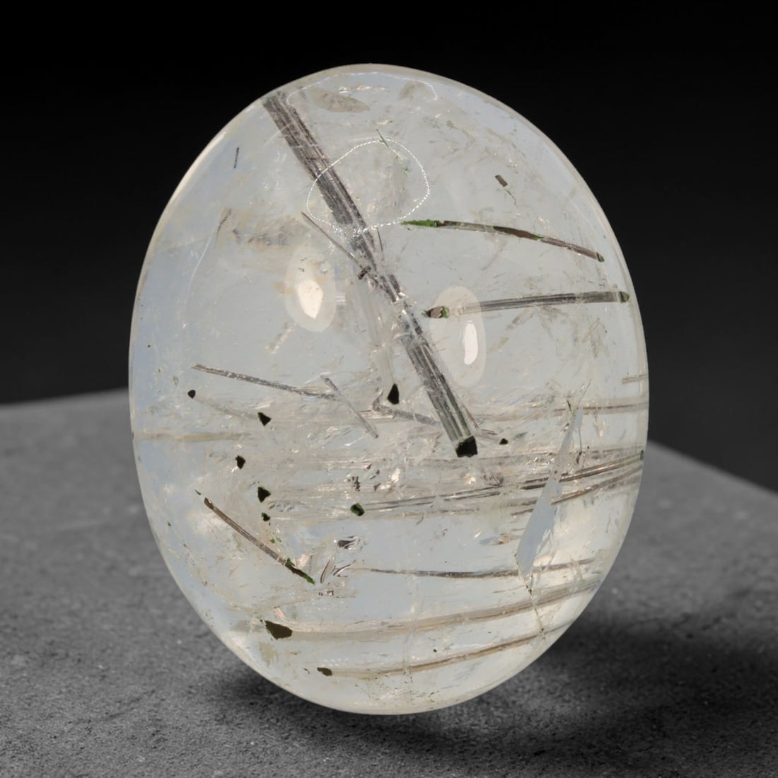 29ct Natural Brazilian Black Rutile Quartz Cabochon Loose Gemstone, 65BM: This polished cabochon of natural rutile quartz features countless distinct slender black rutile needle inclusions suspended within the clear quartz host crystal. The smooth domed surface enables full