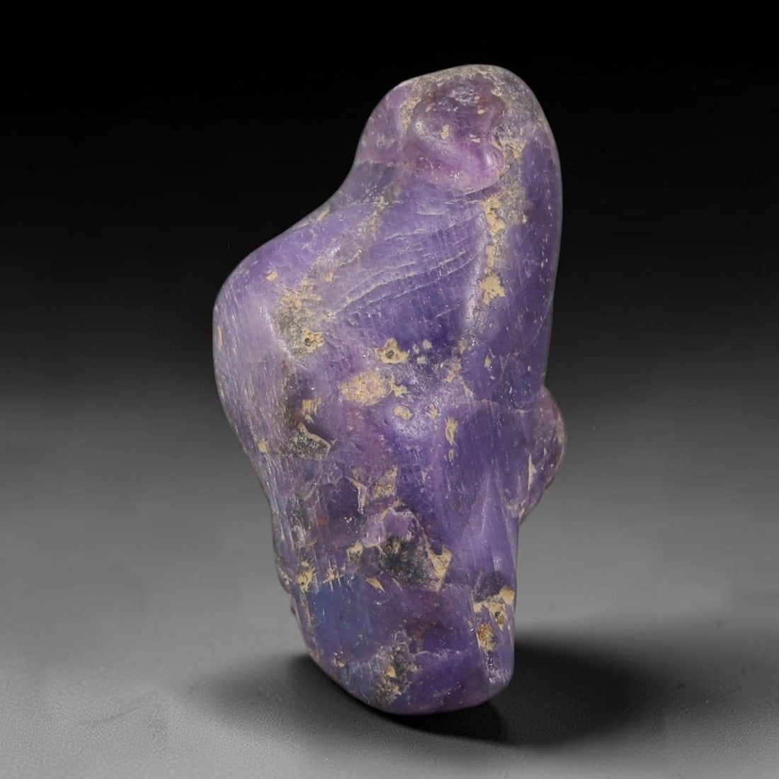 33.34ct Natural Unheated Sri Lankan Purplish Blue Sapphire Rough, 99FC: This natural corundum rough is an unheated purplish blue sapphire sourced from Sri Lankan alluvial gem deposits, featuring an irregular natural native form with residual pale yellow-brown mineral matr