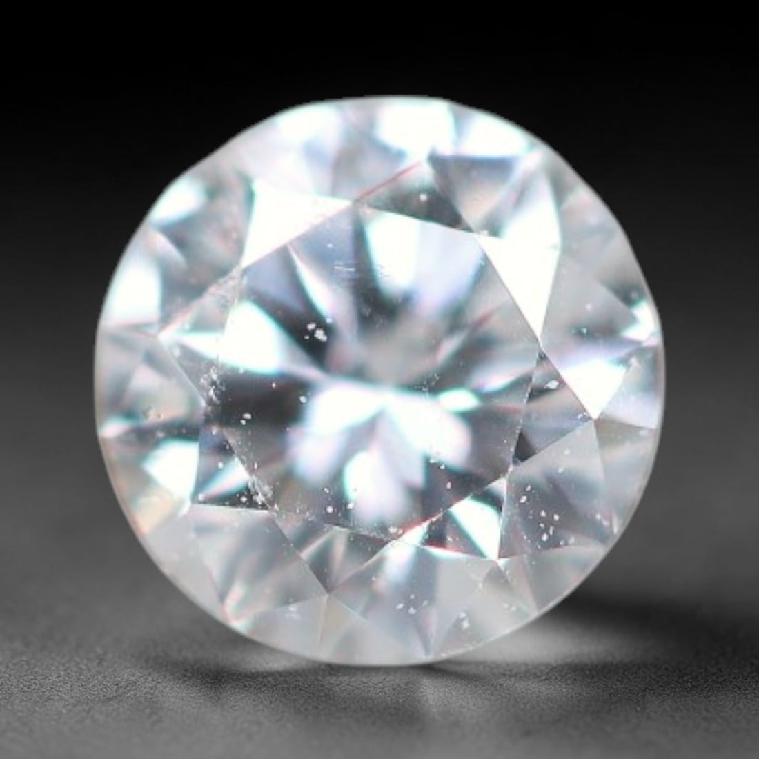 0.12ct Lab-Grown White Round Brilliant HPHT Diamond Loose Gemstone, 84BE: This precision-cut HPHT lab-grown diamond exhibits brilliant colourless transparency, dotted with subtle microscopic growth features within its crystal structure, measured at calibrated dimensions of 