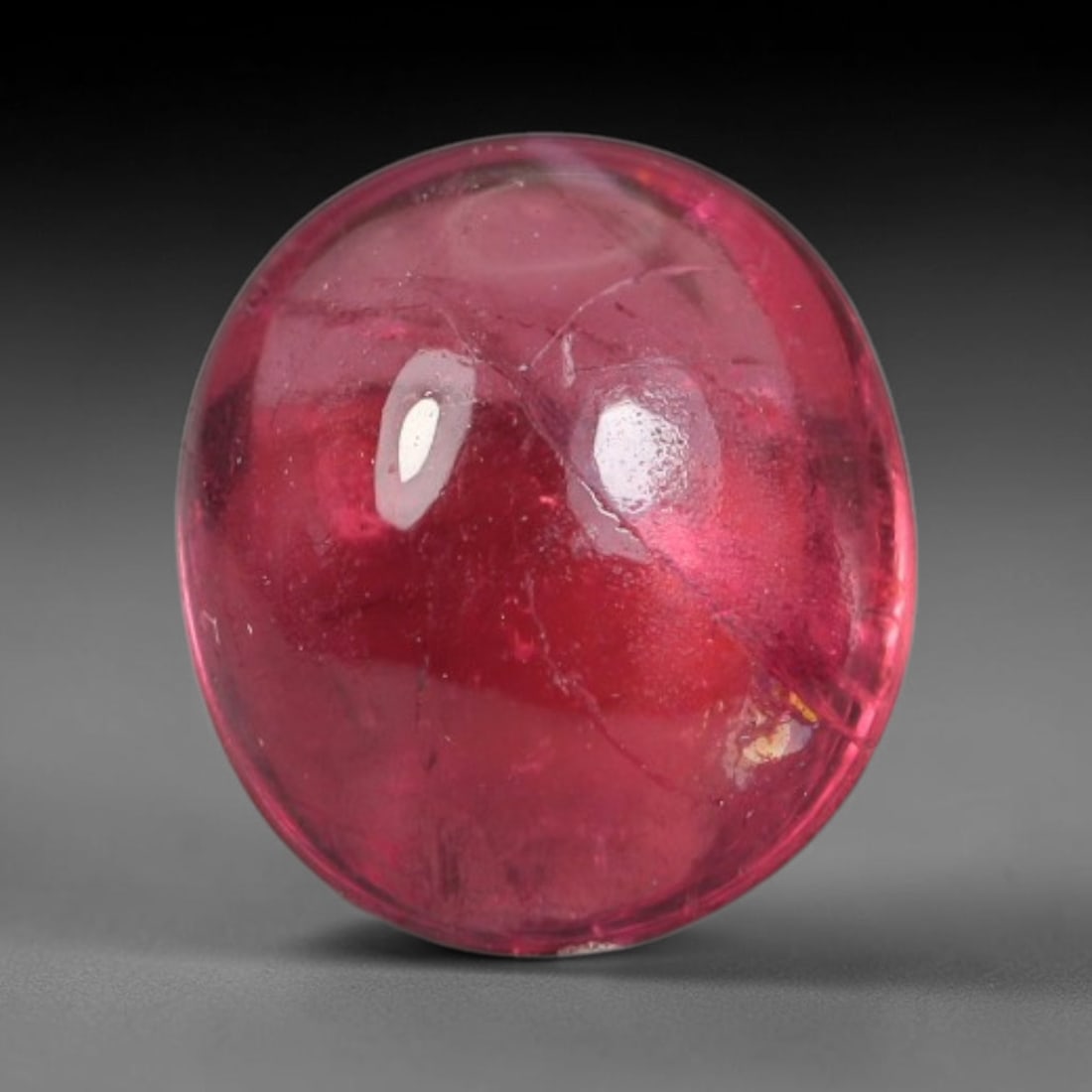 1.48ct Natural Brazilian Rubellite Tourmaline Cabochon Loose Gemstone, 3BC: This smoothly polished cabochon rubellite tourmaline features layered saturated pink-red body saturation with dense natural crystalline mineral flecks and fine internal fracture markings concentrated 