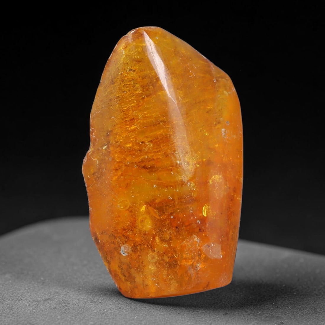 17.11ct Natural Baltic Polished Loose Freeform Amber Gemstone, 39AT: This smoothly polished freeform amber piece carries warm translucent organic clarity with fine natural fossil flecks and tiny mineral inclusions suspended throughout its 30x17mm flowing unstructured s