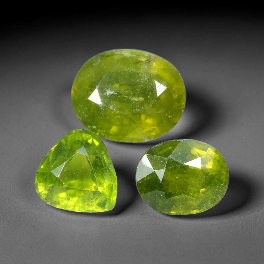9.11ct Natural Madagascan Sphene Loose Gemstone Parcel Lot, 23EV: This attractive parcel of sphene exhibits vivid lively lime-green hues across mixed oval and pear faceted cuts. Sharp faceting unlocks the gem's notable high dispersion, producing bright flashes of co