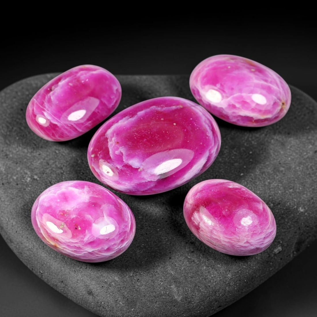 74.27ct Natural Magenta Pink Ruby Cabochon Loose Gemstone Parcel Lot, 40EV: This expressive parcel of ruby cabochons displays rich magenta-pink hues blended with swirling pale milky patterning across smooth polished domed surfaces. The soft undulating banding creates striking