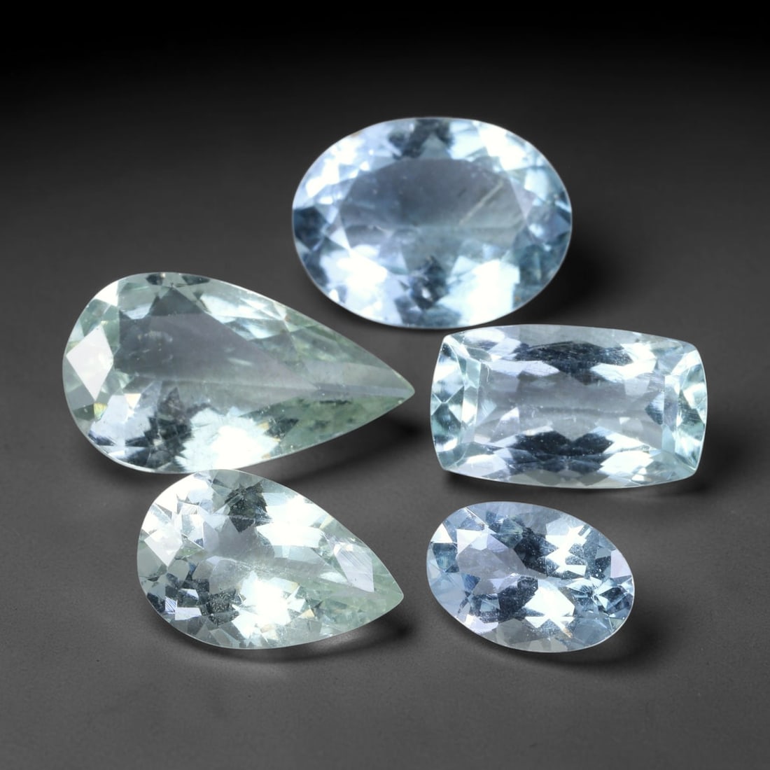 10.60ct Natural Brazilian Sky Blue Aquamarine Loose Gemstone Parcel Lot, 53EV: This lovely parcel of aquamarine displays serene sky-blue cool tones across a varied selection of oval, cushion and emerald faceted cuts. Crisp faceting allows light to travel through each translucent