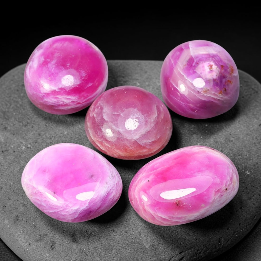 75.47ct Natural Magenta Pink Ruby Cabochon Loose Gemstone Parcel Lot, 39EV: This expressive parcel of ruby cabochons displays rich magenta-pink hues blended with swirling pale milky patterning across smooth polished domed surfaces. The soft undulating banding creates striking