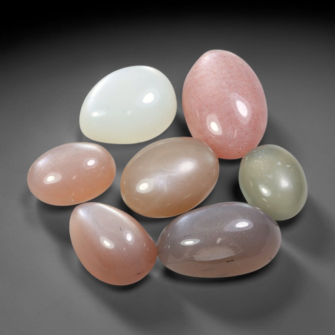 87.53ct Natural Ceylon Moonstone Cabochon Loose Gemstone Parcel Lot, 91EV: This substantial parcel of Ceylon moonstone cabochons showcases soft milky white, warm peach-pink and cool grey-silver tones across smoothly polished oval domed forms. Gentle adularescent sheen drifts