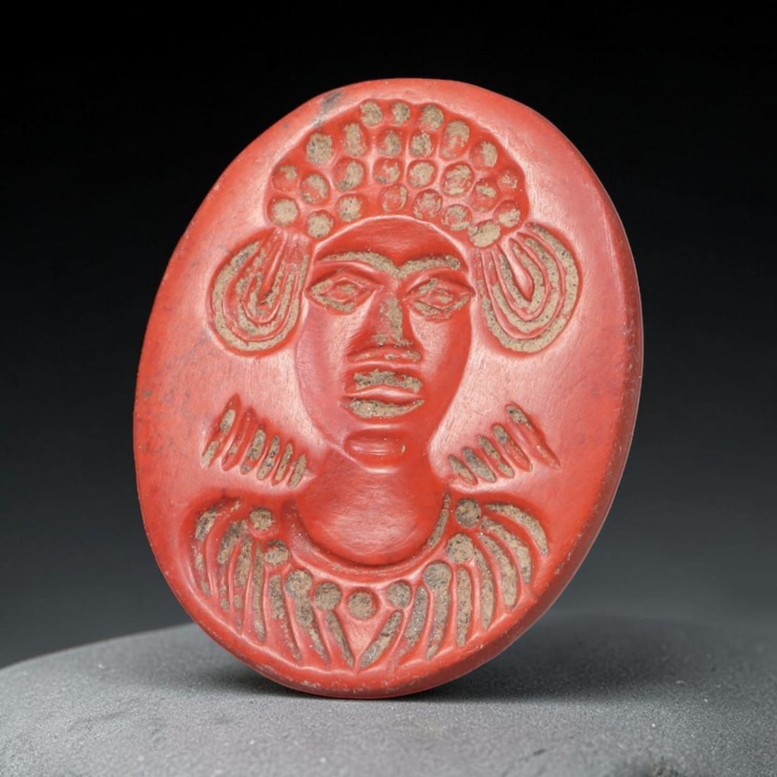 Ancient Sasanian Persian Red Jasper Intaglio Bead (224-651 CE), 73EQ: This antique wearable seal bead is worked from vivid red jasper originating from the Sasanian Persian Empire, featuring a carved frontal bust with elaborate stylized headdress, layered earrings and ce
