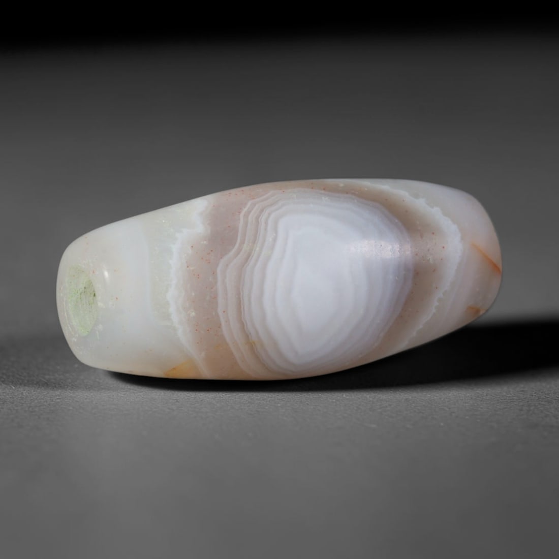 Ancient Mehrgarh Culture Banded Agate Barrel Bead (7000-2600 BCE), 42AD: This antique banded agate barrel bead originates from the Mehrgarh Culture, the world's oldest confirmed agate bead workshop civilization, home to early pecked and drilled agate bead production predat
