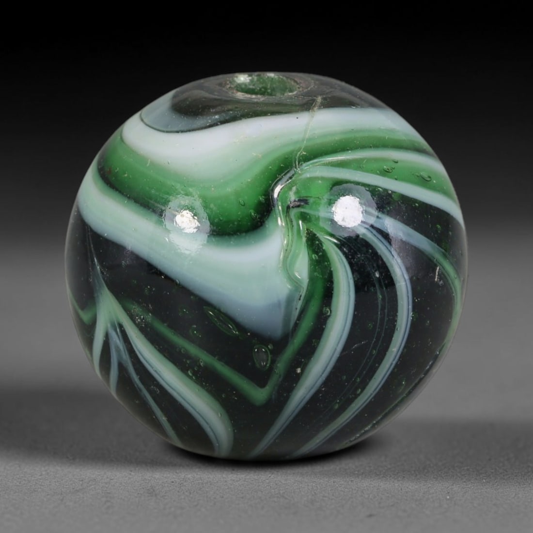 Swirled Green Blown Glass Bead - Handmade Vintage Spherical Ornament, 27AE: Hand-blown glass composes this spherical bead, defined by fluid layered swirls of deep emerald green, soft mint green and opaque white glass forming continuous marbled striations across its polished e