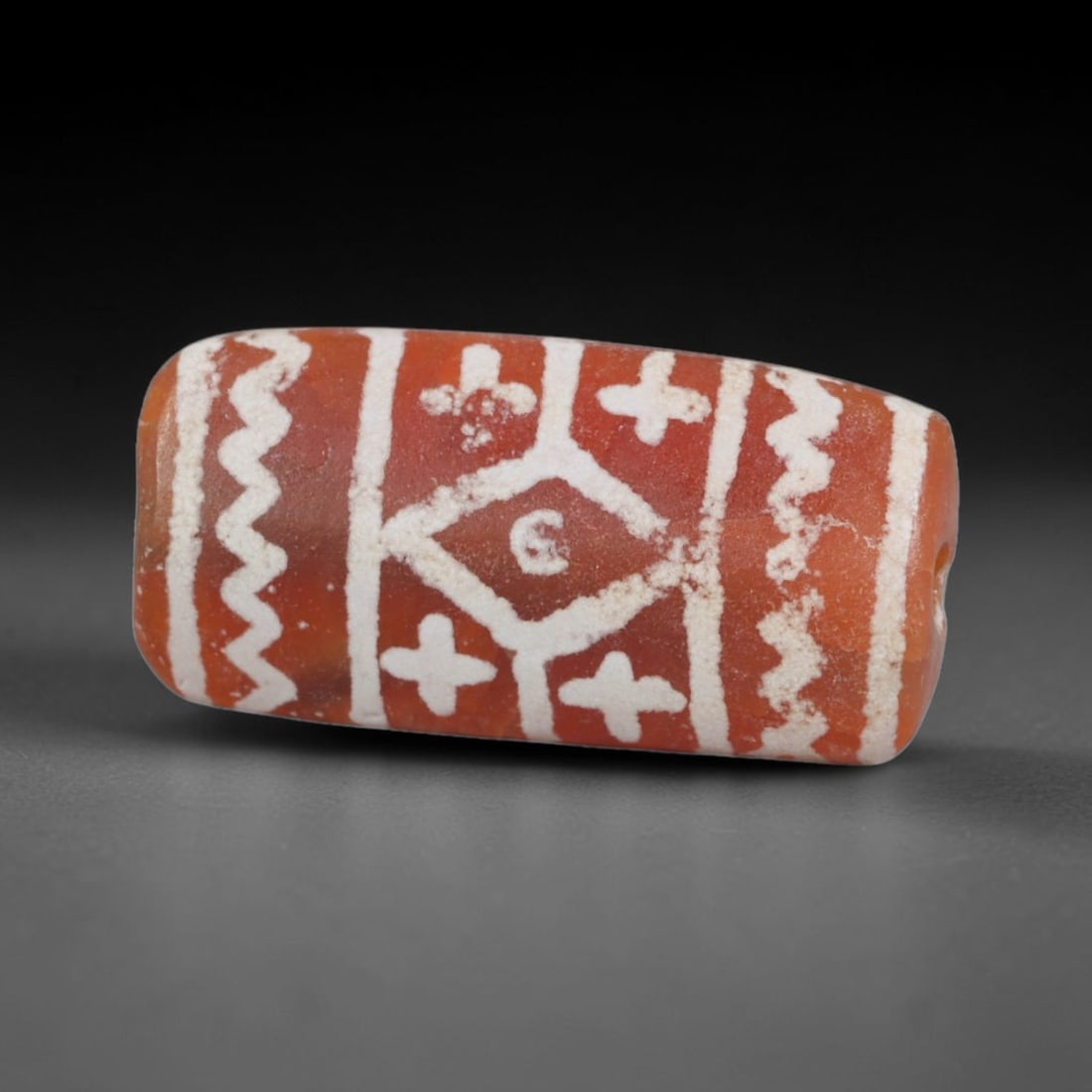 Antique Sino-Himalayan Region Etched Carnelian Bead, 83EG: Antique etched carnelian bead originating from the Sino-Himalayan region. Exhibits characteristic surface patina and traditional etched white decoration. Dimensions: 18x8mm, fully pierced for suspensi