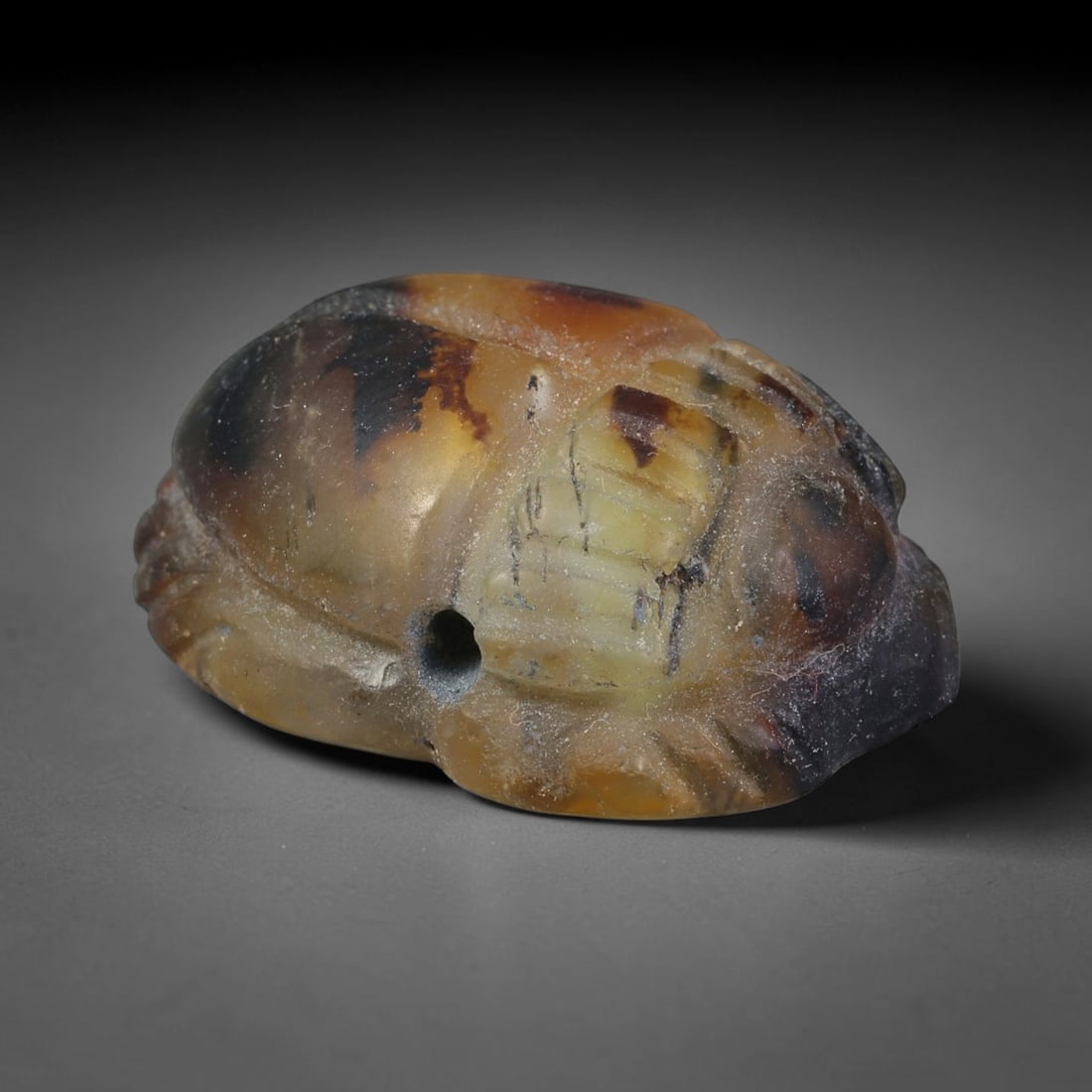 Ancient Pharaonic Egyptian Agate Scarab Amulet Bead (3100 BCE-30 CE), 32EC: This antique scarab amulet bead is carved from natural agate, originating from Pharaonic Egyptian culture. Scarabs were sacred protective talismans closely linked to rebirth and eternal life within an