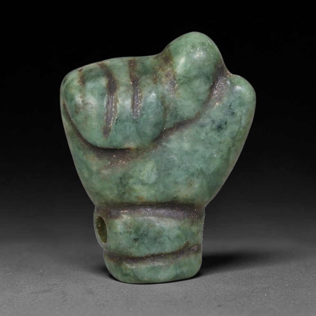 Ancient Medieval Near Eastern Serpentine Fist Talisman Amulet (650-1200 CE), 50AB: Hand-carved serpentine fist-shaped wearable amulet originating from medieval Near Eastern trade cultures, crafted as a protective symbolic talisman worn to convey strength and ward off harm. The piece