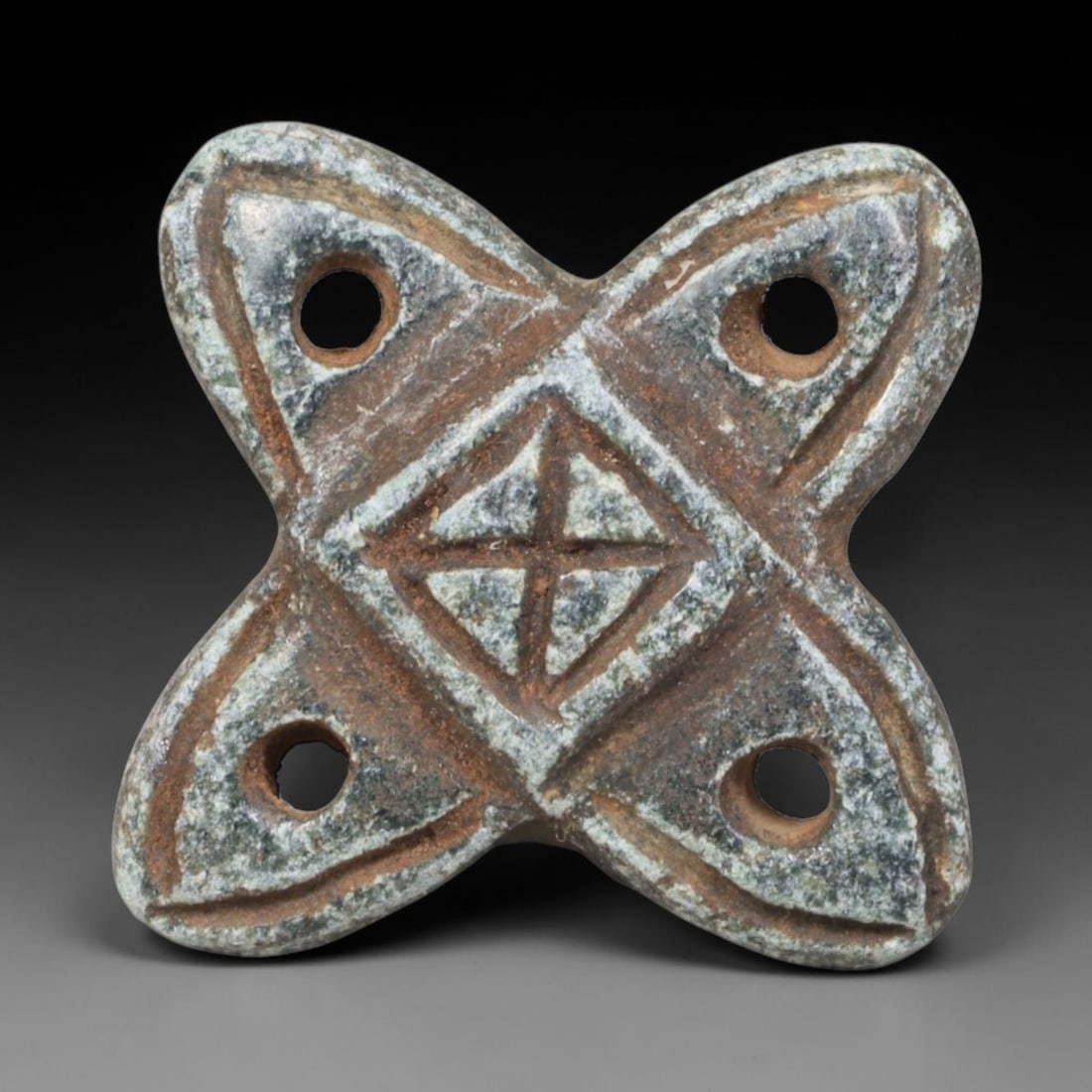 Early Islamic Abbasid Steatite Four-Lobed Cross Talisman Plaque (c.750-950 CE), 95EQ: Carved from mottled green-grey steatite stone originating from Abbasid Caliphate territories of the Iranian plateau. This flat wearable amulet features symmetrical four-lobed form with four perforatio