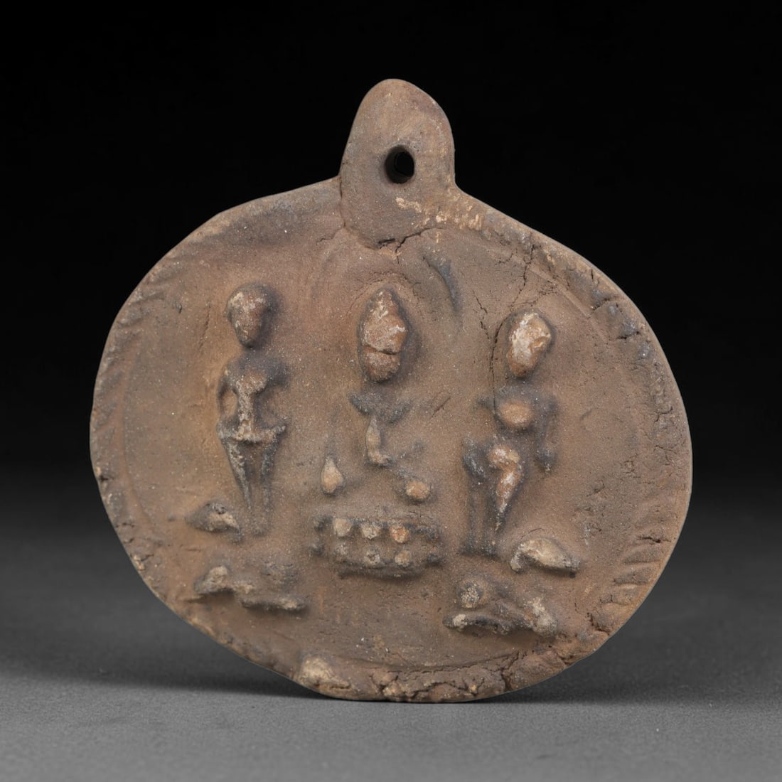 Ancient Gandhara Terracotta Buddhist Plaque (100 BCE-400 CE), 44EK: This ancient terracotta pendant plaque originates from Gandhara, a major centre of early Buddhist art along the Silk Road, shaped as a wearable devotional amulet with an integral suspension hole. The 
