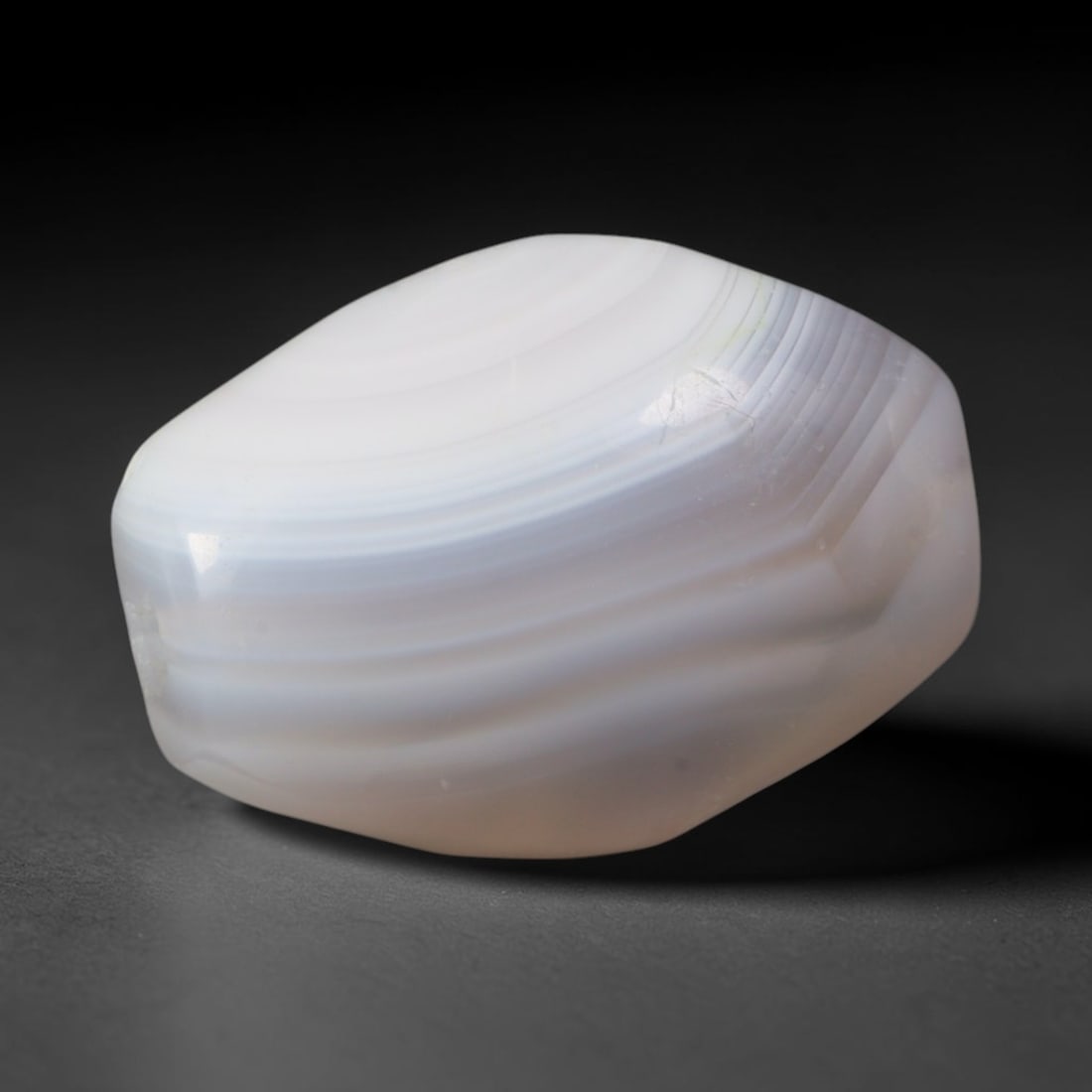 Ancient Elamite Civilization Faceted Banded Agate Barrel Bead (2700-539 BCE), 72AD: This antique faceted banded agate barrel bead originates from the Elamite Civilization of the Iranian Plateau, a pre-Persian culture renowned for refined agate lapidary traditions that supplied ritual