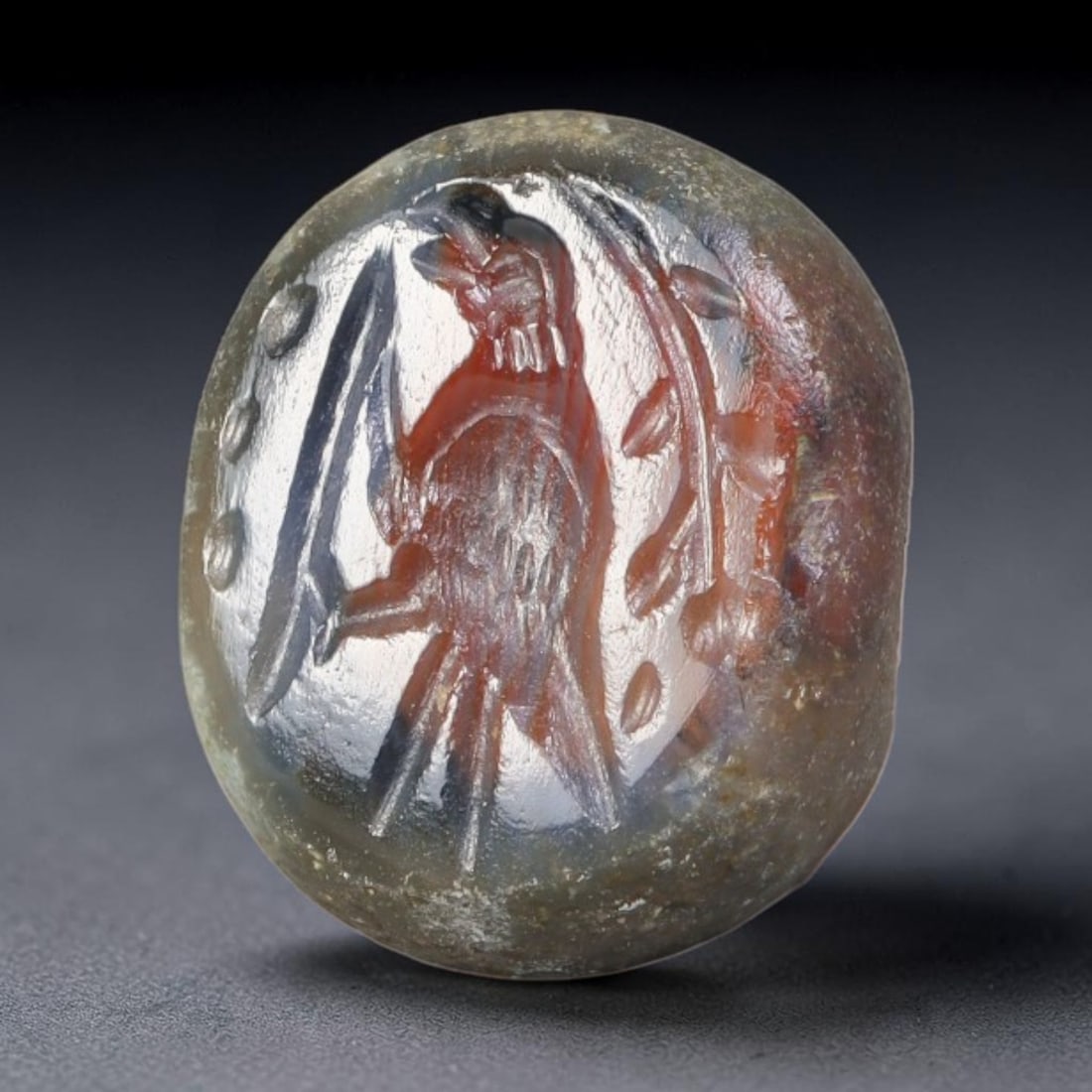 Ancient Sasanian Persian Hardstone Bird Motif Stamp Seal (224-651 CE), 75EQ: This domed wearable stamp seal is carved from mottled translucent hardstone originating from the Sasanian Persian Empire. The oval seal face features an intaglio depiction of a standing bird enclosed 