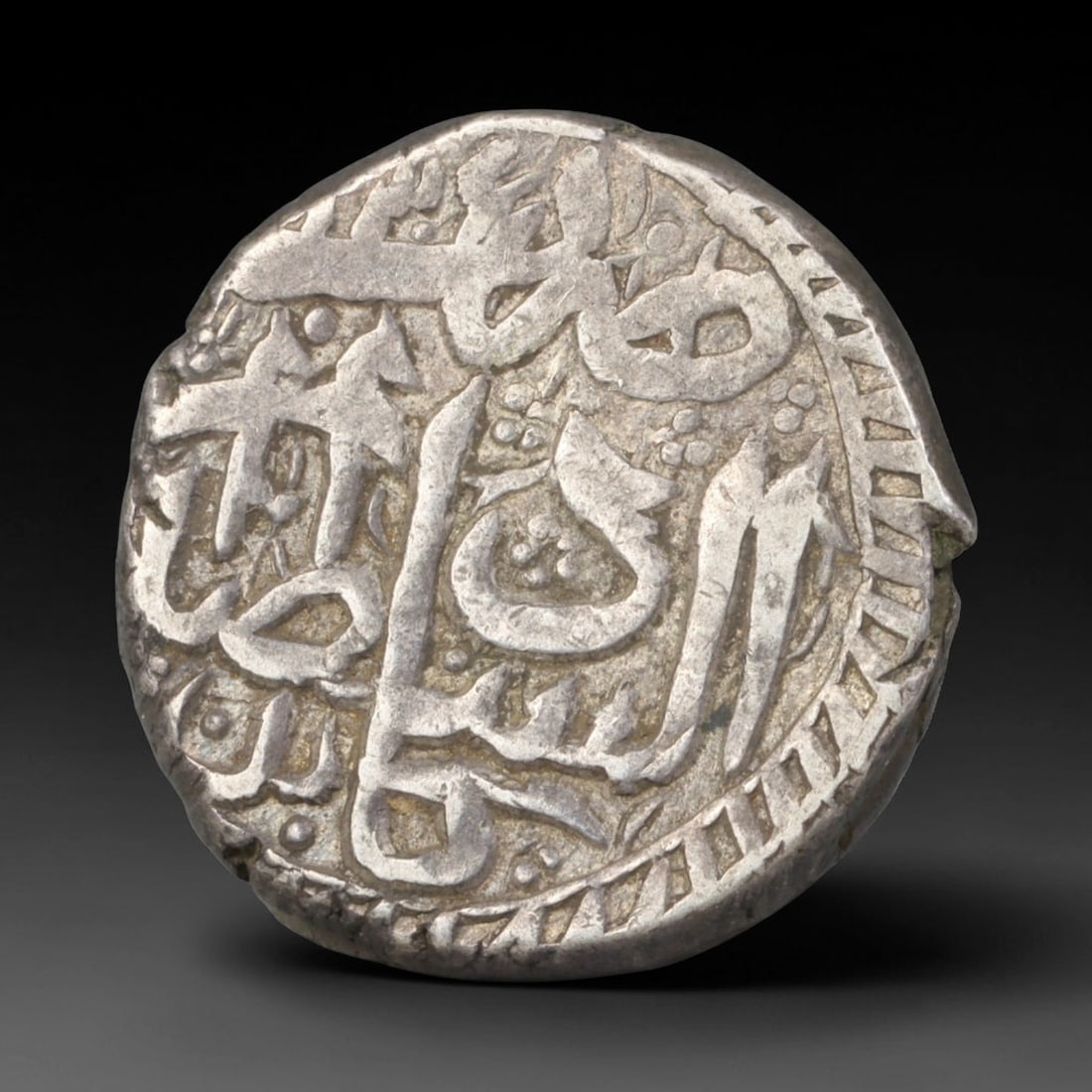 Antique Mughal Islamic Calligraphic Silver Coin (1526-1857 CE), 53EQ: This authentic silver coin originates from the Mughal Empire, struck with elegant flowing Islamic calligraphic script arranged across both obverse and reverse faces, characteristic of Mughal numismati