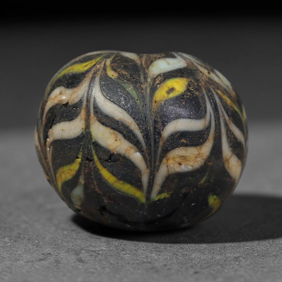 Ancient Islamic Hand Crafted Glass Bead Talisman, 33AC: Miniature antique wearable bead formed from hand-worked glass material, originating from ancient Islamic period glassmaking traditions across the Near East and North African cultural spheres. Glass wa