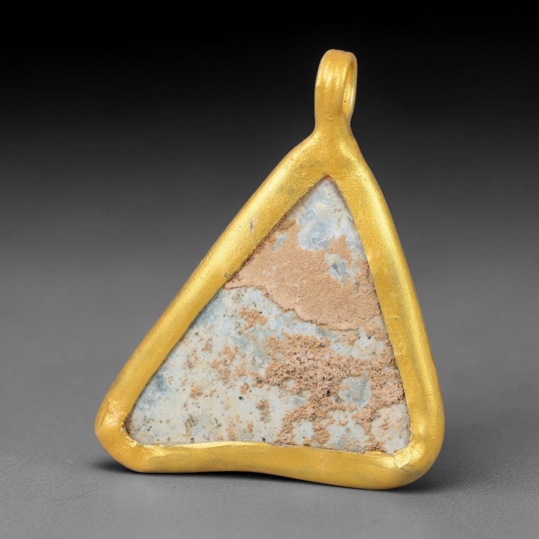 Ancient Roman Glass Slag in Modern Gilt-Edge Pendant, 22EH: This contemporary pendant is crafted from ancient Roman glass slag, featuring a fragmented, iridescent glass surface with weathered patina. The irregular form is bordered by a subtle gilt frame, added