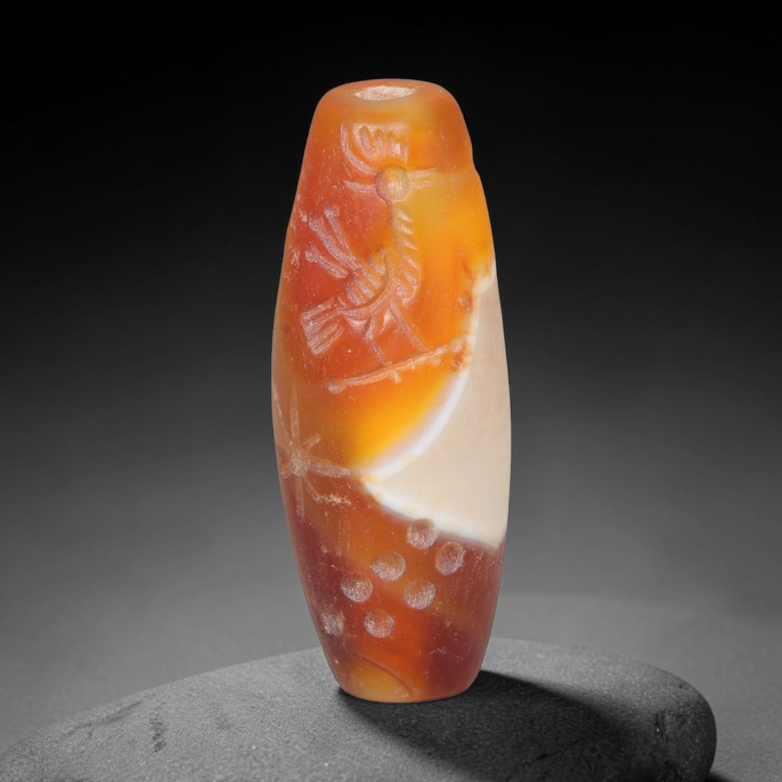 Ancient Achaemenid Persian Carnelian Cylinder Seal (550-330 BCE), 98EQ: This cylindrical seal is carved from warm translucent carnelian originating from the Achaemenid Persian cultural sphere, engraved with a scene featuring a standing human figure confronting a horned be