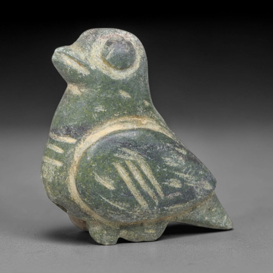 Ancient Bactrian Serpentine Dove Effigy Amulet (c.200-200 BCE), 90EQ: Carved from mottled dark green serpentine stone originating from ancient Bactria, Central Asia. This compact standing dove figurine is a wearable protective talisman with clean incised detailing marki
