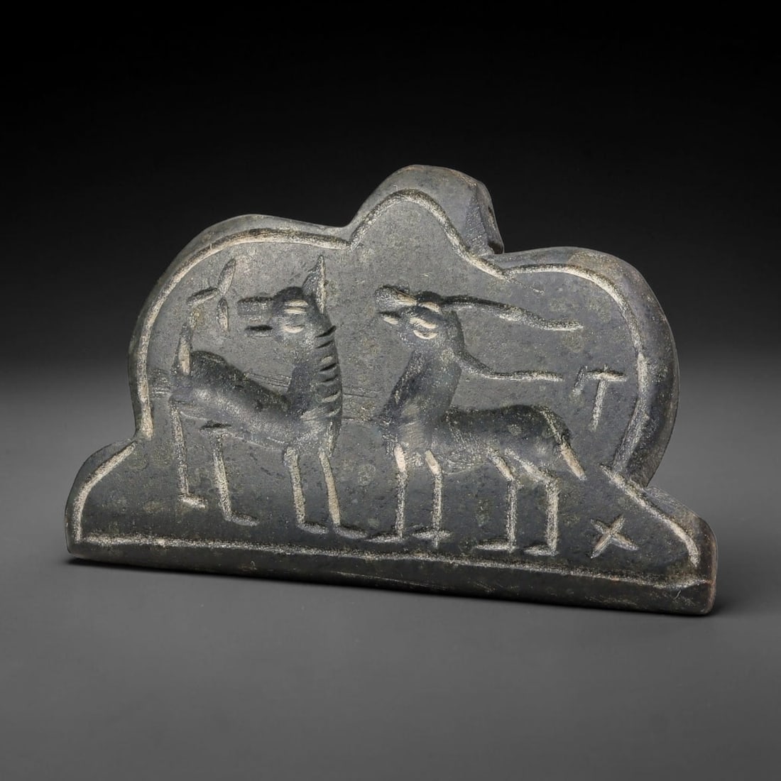 Vintage Dark Stone Sasanian Revival Dual Zoomorphic Talisman Amulet Plaque, 62FL: This hand-carved dark stone amulet plaque follows glyptic traditions inspired by Sasanian artistic styles. The shaped plaque bears incised imagery of paired zoomorphic creatures alongside simple symbo