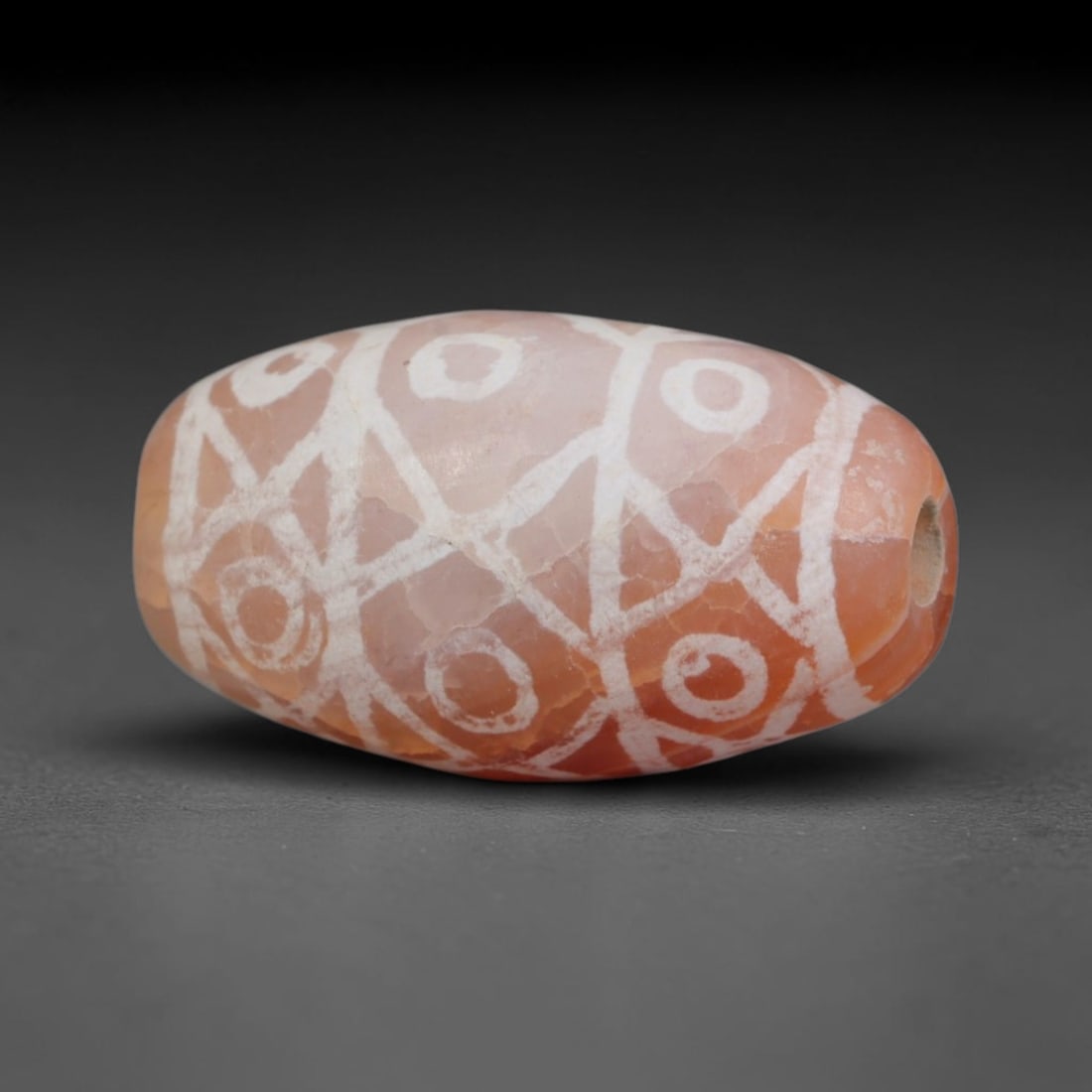 Antique Sino-Himalayan Region Etched Carnelian Bead, 20EH: Antique etched carnelian bead originating from the Sino-Himalayan region. Exhibits characteristic surface patina and traditional etched white decoration. Dimensions: 17x9mm, fully pierced for suspensi