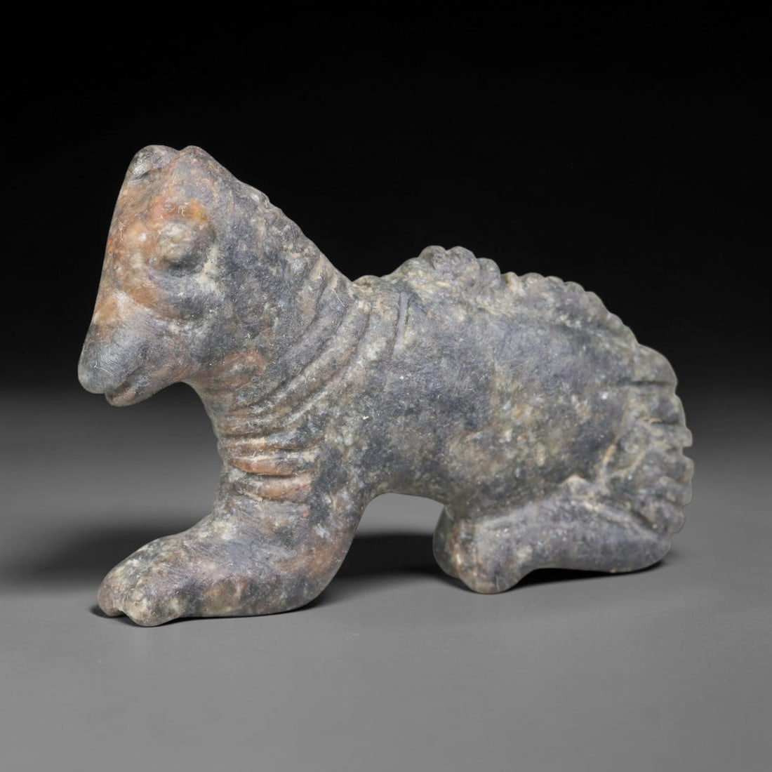 Ancient Medieval Seljuk Islamic Zoomorphic Guardian Beast Effigy Amulet (c.1037-1194 CE), 4ER: Hand-carved from dark mottled serpentine stone originating from the medieval Seljuk Islamic territories of Iran. Rendered in crouched pose as a stylised mythic quadruped guardian beast effigy, this mi