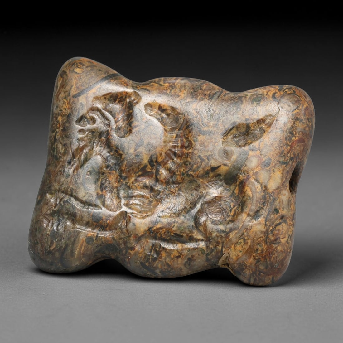 Ancient Sasanian Persian Fossil Stone Intaglio Bead (224-651 CE), 70EC: This antique naturally patterned fossil matrix stone intaglio bead originates from the Sasanian Persian Empire, a culture that preserved and revived ancient Mesopotamian lamassu imagery for wearable p