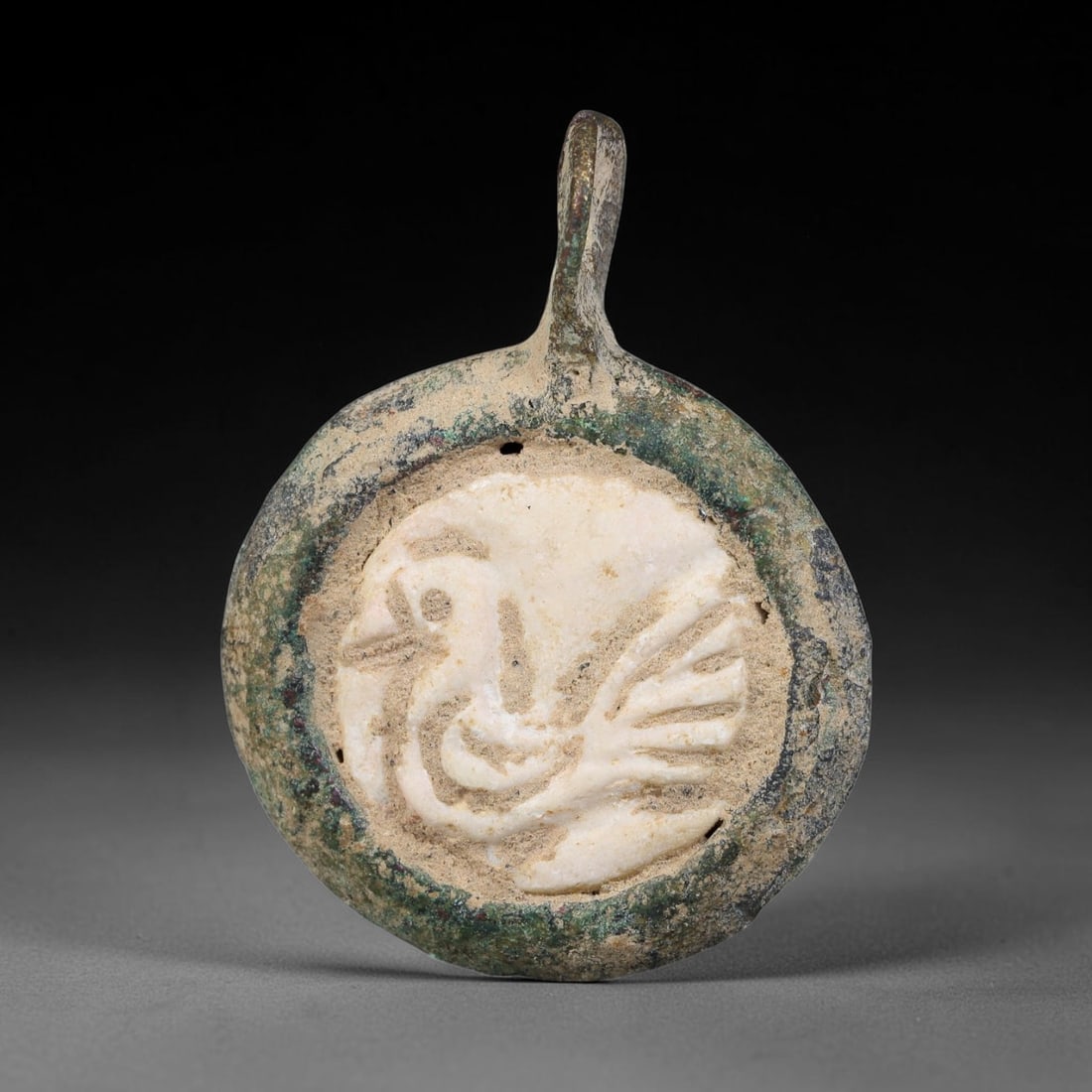 Ancient Medieval Byzantine Bronze Pendant With Stone Cameo (500-1200 CE), 74EH: This antique circular bronze pendant originates from medieval Byzantine cultural tradition, set with an inset carved stone cameo and made to serve as a wearable protective personal amulet. The bronze 