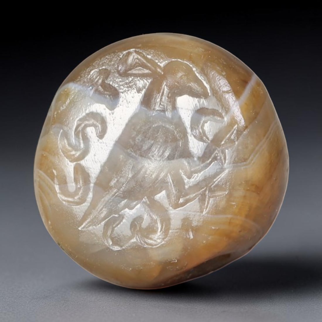 Ancient Sasanian Persian Banded Agate Avian Motif Stamp Seal (224-651 CE), 74EQ: This domed wearable stamp seal is carved from naturally layered banded agate originating from the Sasanian Persian Empire. The circular intaglio face features a finely engraved standing avian figure s