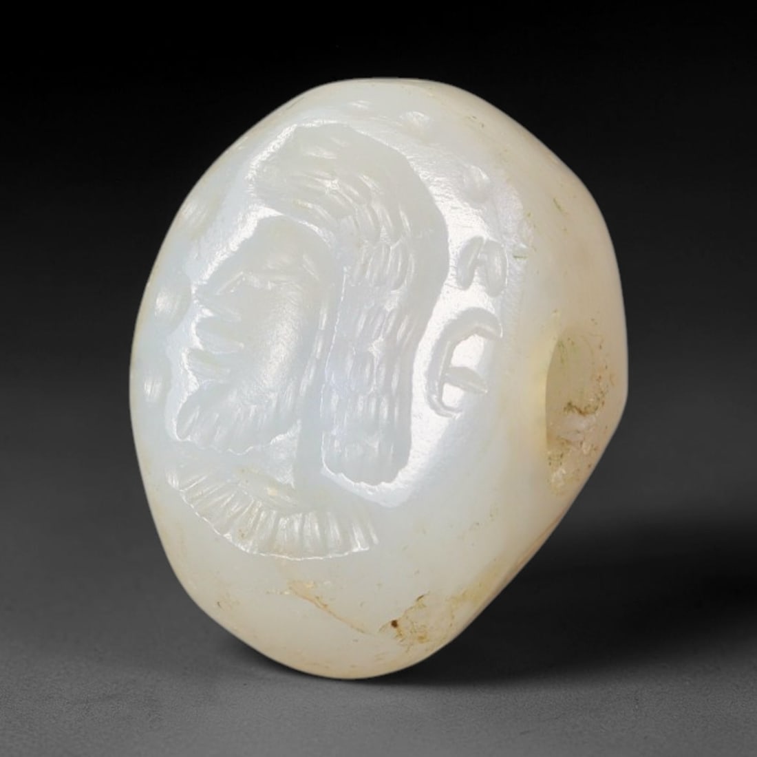 Ancient Sasanian Persian White Banded Agate Portrait Intaglio Stamp Seal (224-651 CE), 100EQ: This domed wearable stamp seal is carved from pale white banded agate originating from the Sasanian Persian Empire. The oval intaglio surface bears a finely engraved profile bust of a bearded noble ma